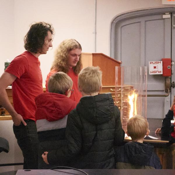 Grad students demonstrate the fire tornado effect to kids during Physics Family Fun Day