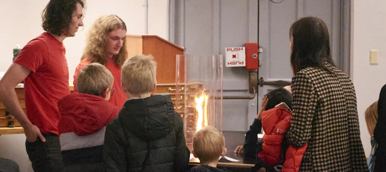 Grad students demonstrate the fire tornado effect to kids during Physics Family Fun Day
