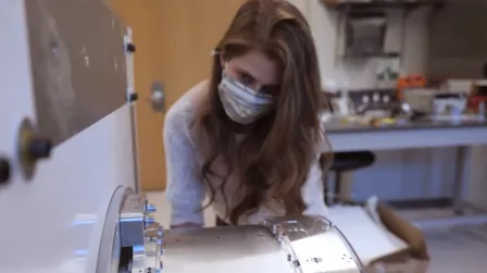 Grad student working on equipment in a physics lab