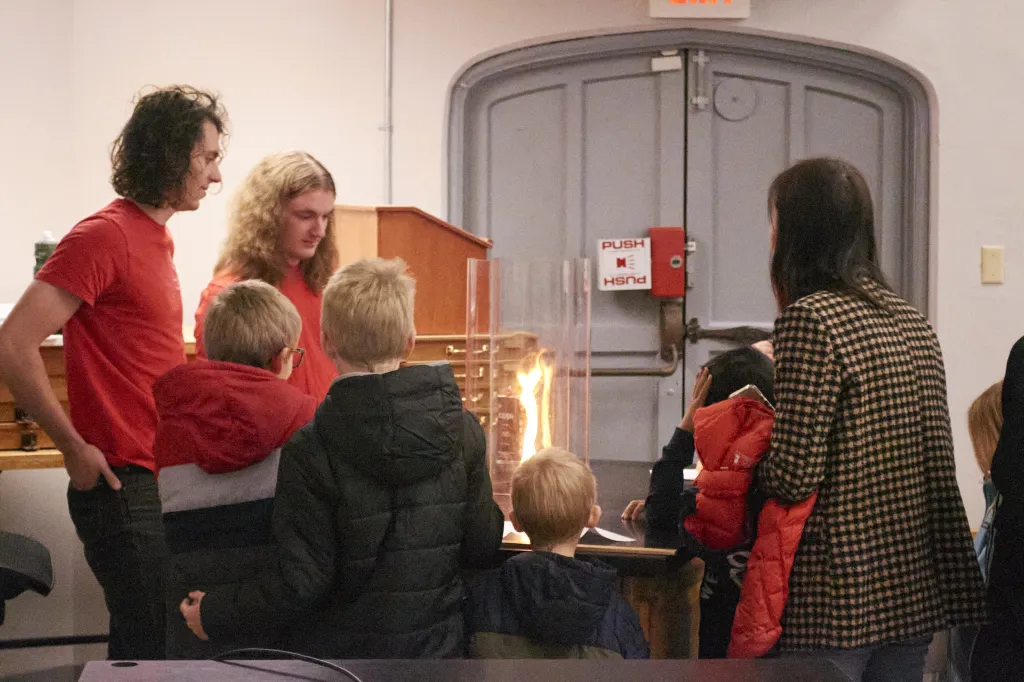 Grad students demonstrate the fire tornado effect to kids during Physics Family Fun Day