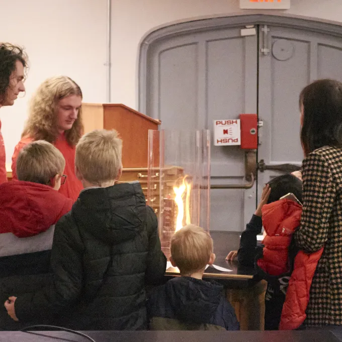 Grad students demonstrate the fire tornado effect to kids during Physics Family Fun Day